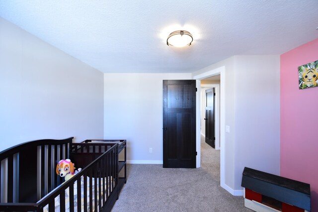 carpeted bedroom featuring baseboards and a textured ceiling