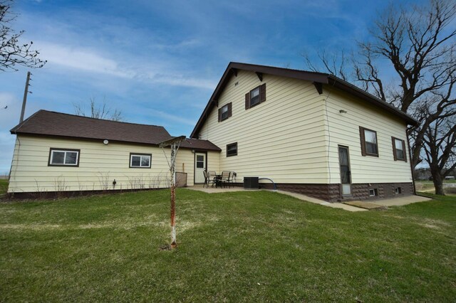 back of property with a lawn and a patio area