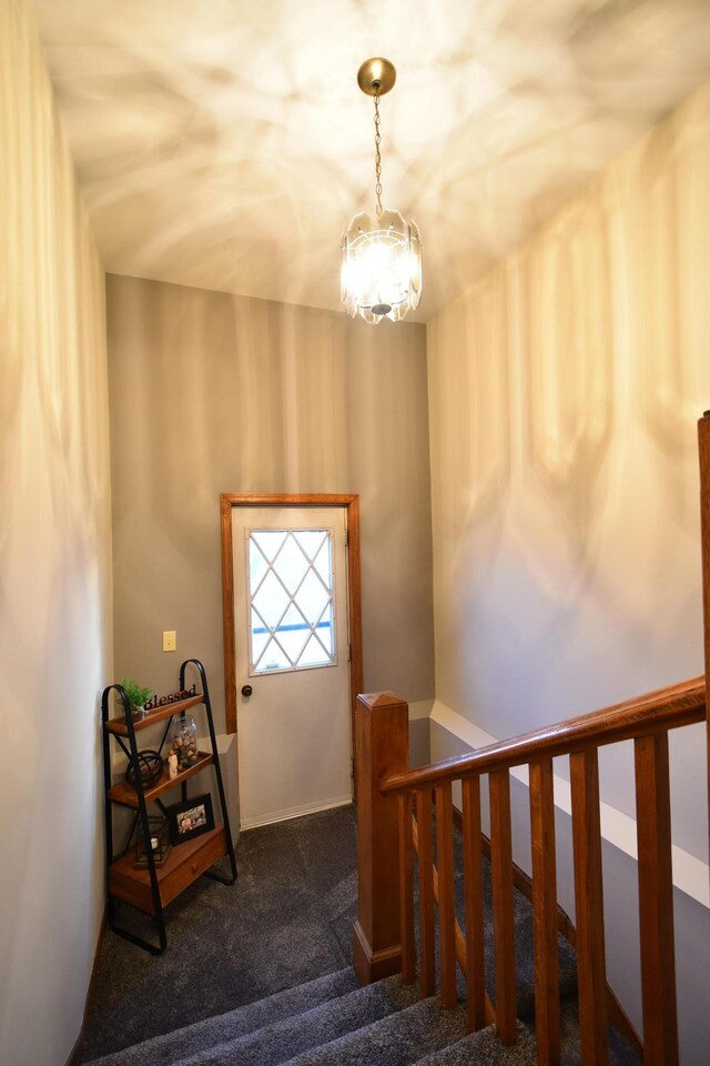 stairway with baseboards, carpet flooring, and an inviting chandelier