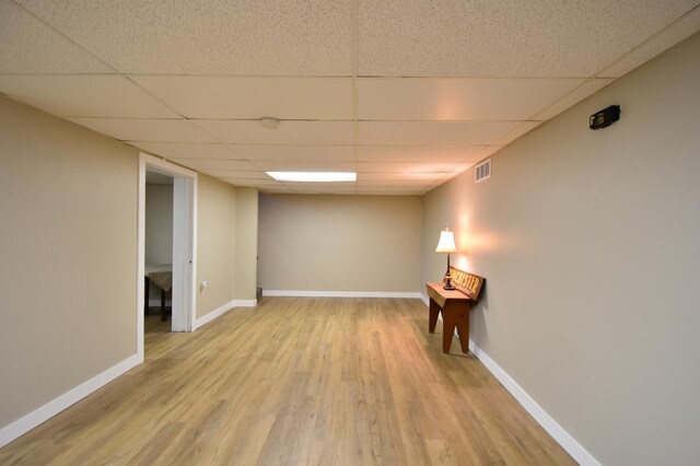 interior space featuring visible vents, baseboards, wood finished floors, and a drop ceiling