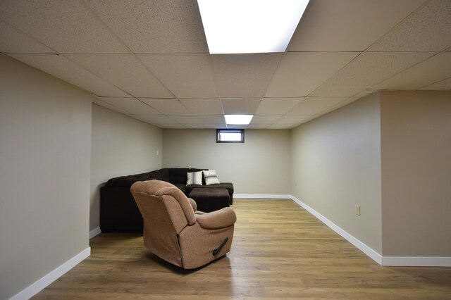 sitting room featuring wood finished floors, baseboards, and a drop ceiling