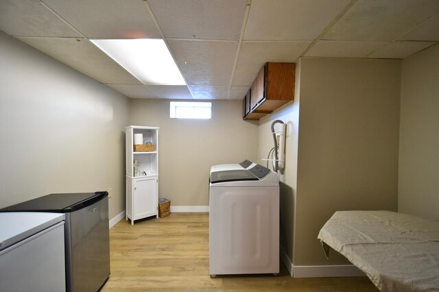 washroom featuring cabinet space, light wood finished floors, and washer and dryer