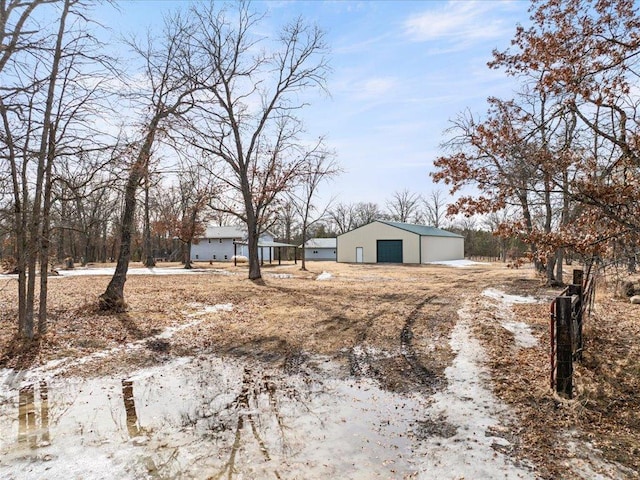 view of yard with a pole building, a detached garage, and an outbuilding