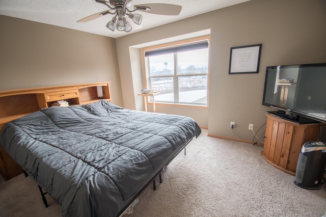 carpeted bedroom featuring ceiling fan, a textured ceiling, and baseboards