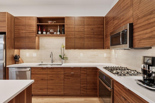 kitchen with decorative backsplash, stainless steel appliances, modern cabinets, and a sink