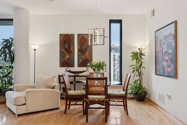 dining area featuring visible vents, light wood-type flooring, and baseboards