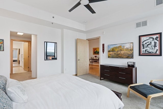 bedroom with visible vents, light colored carpet, and ceiling fan