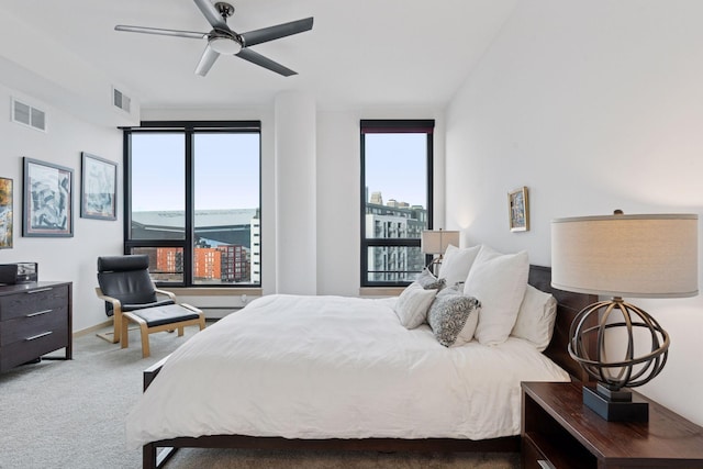 bedroom featuring a view of city, carpet flooring, a ceiling fan, and visible vents