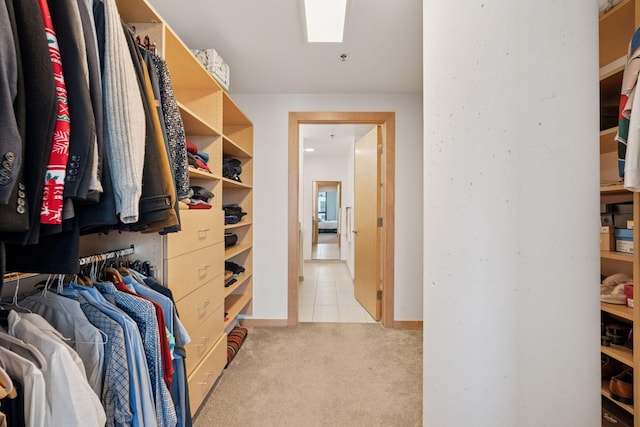 spacious closet with tile patterned flooring, a skylight, and carpet