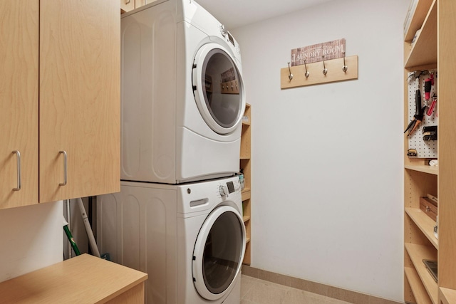 laundry room with cabinet space and stacked washer / dryer