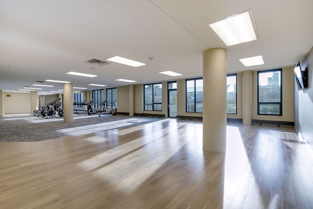 gym with a wall of windows, visible vents, and wood finished floors