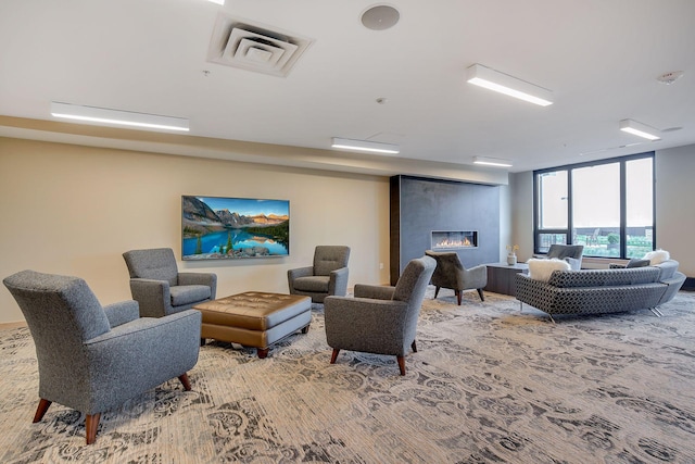 living room with visible vents, a fireplace, and a wall of windows