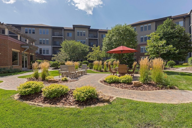 view of property's community featuring a patio area and a lawn