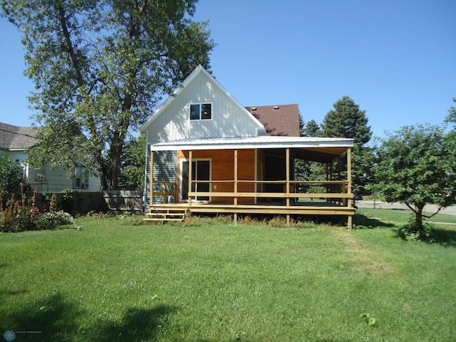 back of house with a porch, a yard, and metal roof