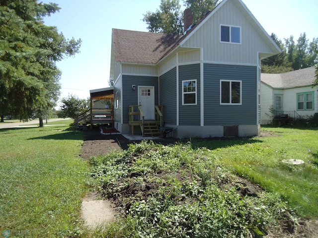 exterior space featuring a lawn, a shingled roof, a chimney, and entry steps