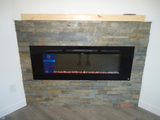 212 May Ave, Page, ND 58064 - detailed view of baseboards, wood finished floors, and a glass covered fireplace