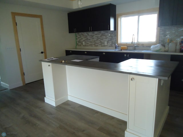 212 May Ave, Page, ND 58064 - kitchen with a sink, tasteful backsplash, dark wood-style floors, dark cabinetry, and baseboards
