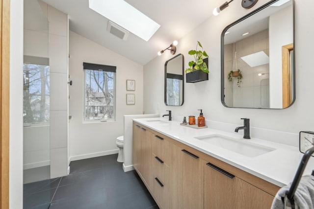 bathroom featuring toilet, vaulted ceiling with skylight, a sink, and visible vents