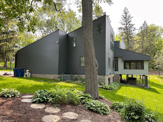 view of side of home featuring a yard and central AC unit