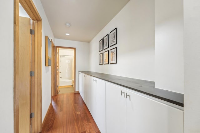 hall with dark wood-style floors and baseboards