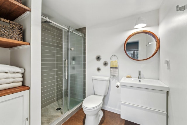 bathroom with toilet, a shower stall, vanity, and baseboards