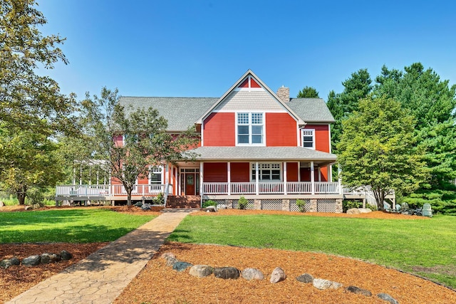 view of front facade with a front lawn, a chimney, and a porch