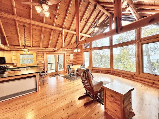living area featuring wood ceiling, light wood finished floors, high vaulted ceiling, healthy amount of natural light, and rustic walls