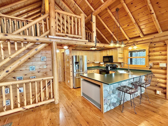 kitchen featuring black appliances, a sink, wood ceiling, high vaulted ceiling, and a peninsula