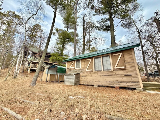 view of front of house with metal roof, an outbuilding, and an attached garage