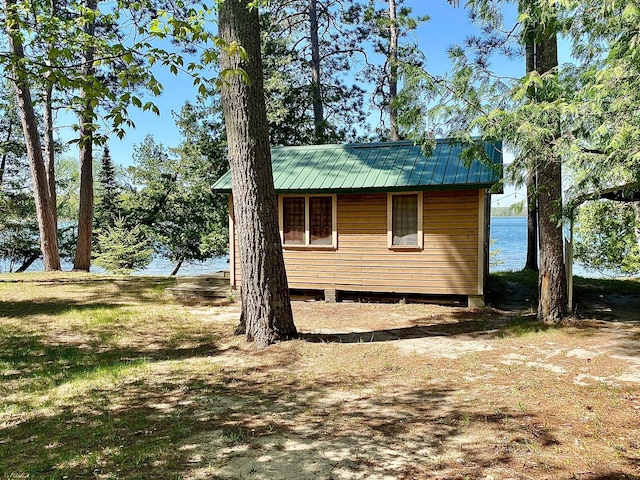 view of side of property with metal roof and a water view