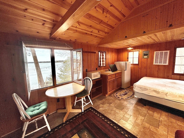 bedroom featuring freestanding refrigerator, wooden walls, wooden ceiling, and stone finish floors