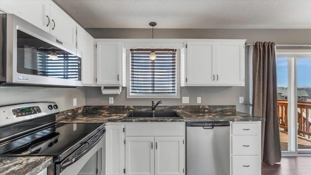 kitchen featuring stainless steel appliances, plenty of natural light, white cabinetry, and a sink