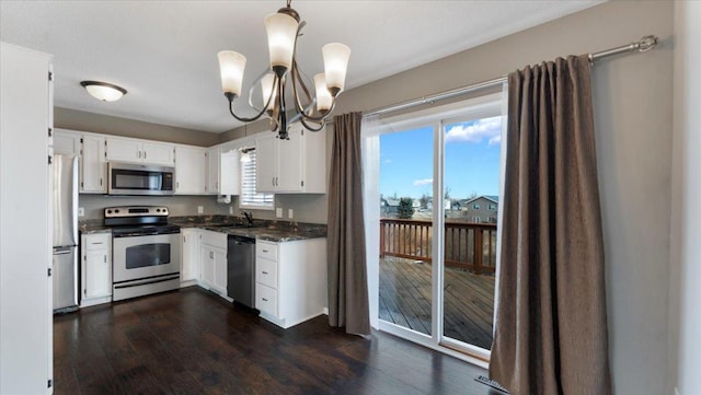 kitchen with stainless steel appliances, white cabinets, dark wood-type flooring, and an inviting chandelier