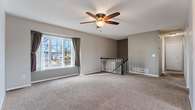 unfurnished room with baseboards, visible vents, ceiling fan, and carpet flooring