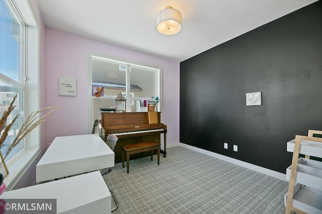 carpeted home office featuring baseboards