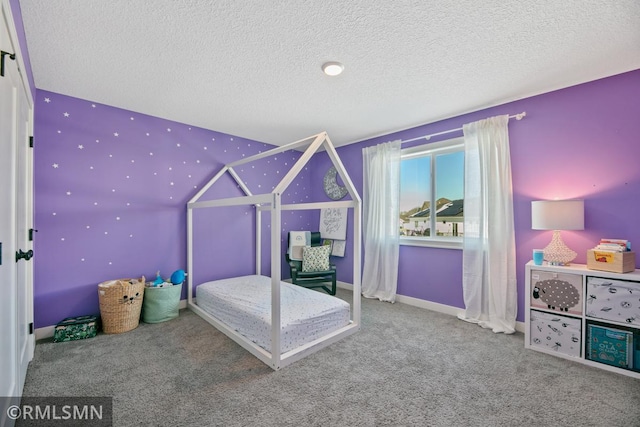 unfurnished bedroom with carpet, a textured ceiling, and baseboards