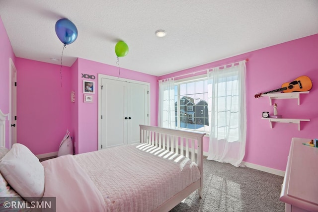 carpeted bedroom featuring a closet, a textured ceiling, and baseboards