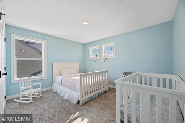 carpeted bedroom with baseboards and a textured ceiling