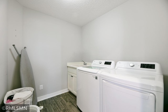 washroom featuring a textured ceiling, separate washer and dryer, a sink, baseboards, and dark wood finished floors