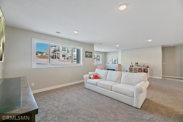 carpeted living area featuring baseboards, a textured ceiling, and recessed lighting