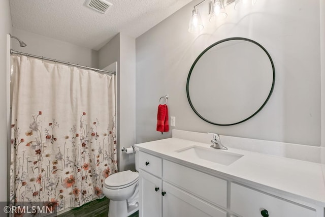 bathroom featuring a textured ceiling, toilet, vanity, visible vents, and a shower with curtain