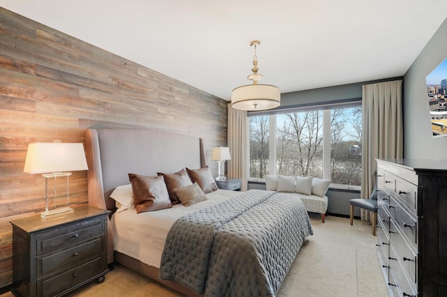 bedroom with light carpet and wood walls