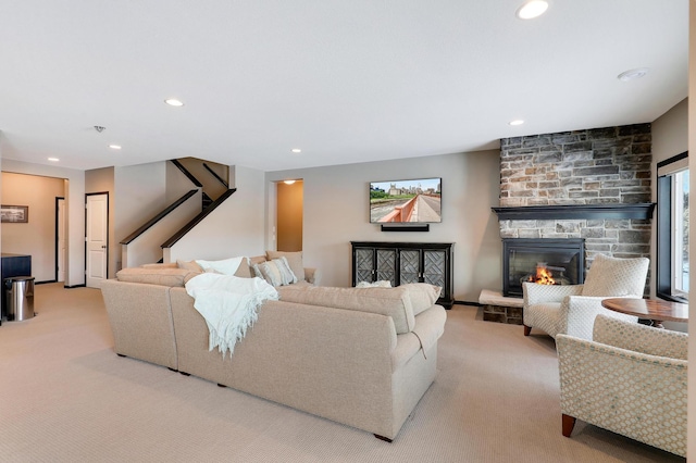 living area with stairs, recessed lighting, a fireplace, and light colored carpet