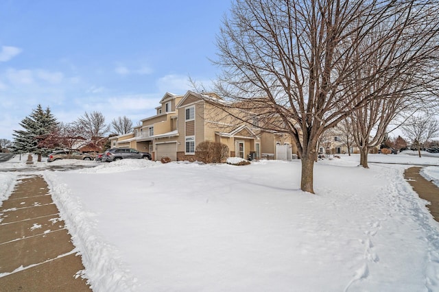 snow covered property featuring a garage