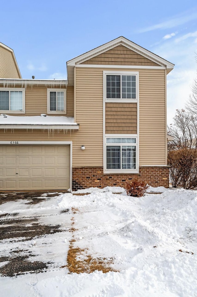 view of front of home with an attached garage and brick siding