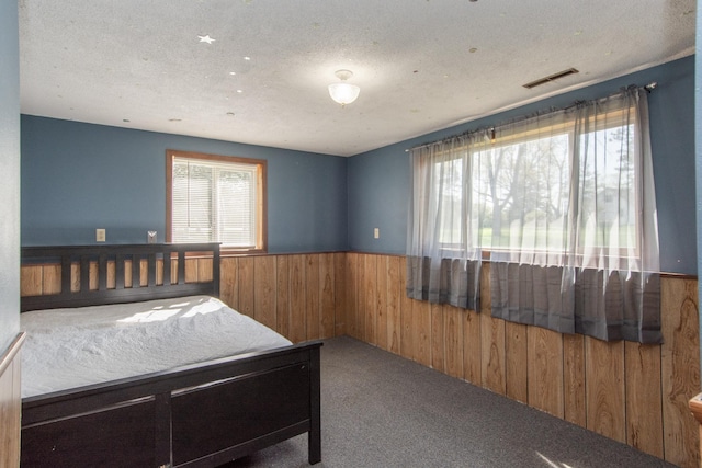 4647 County Road 121, Fort Ripley, MN 56449 - bedroom with wood walls, a wainscoted wall, carpet, and a textured ceiling