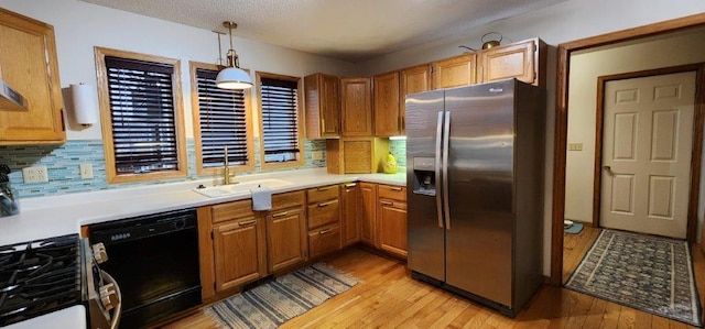 kitchen featuring range with gas stovetop, a sink, light wood-type flooring, dishwasher, and stainless steel refrigerator with ice dispenser
