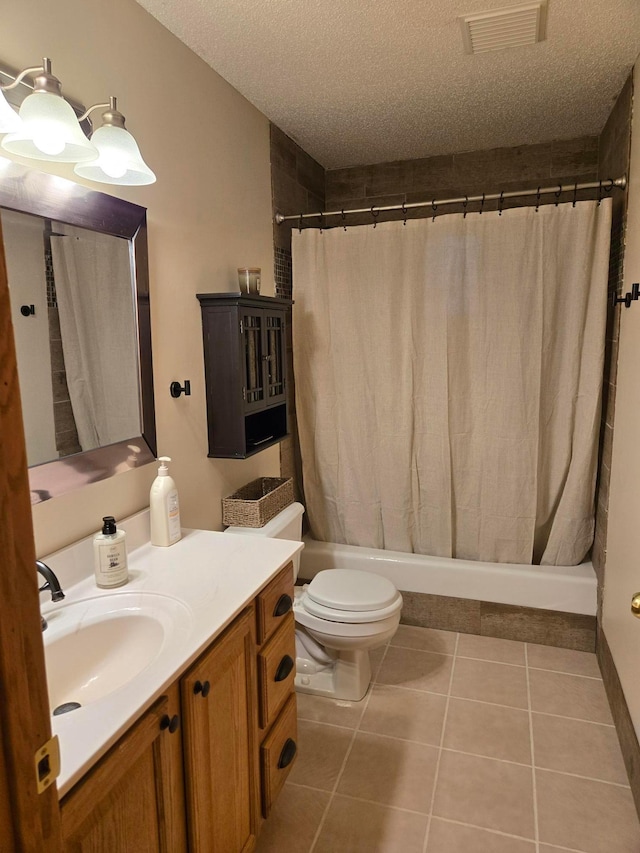 bathroom featuring tile patterned floors, a textured ceiling, toilet, visible vents, and vanity