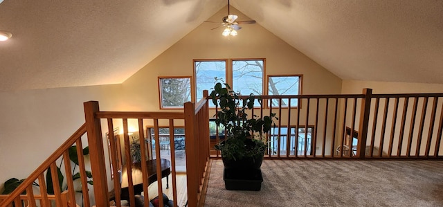 additional living space with carpet floors, a textured ceiling, lofted ceiling, and a ceiling fan