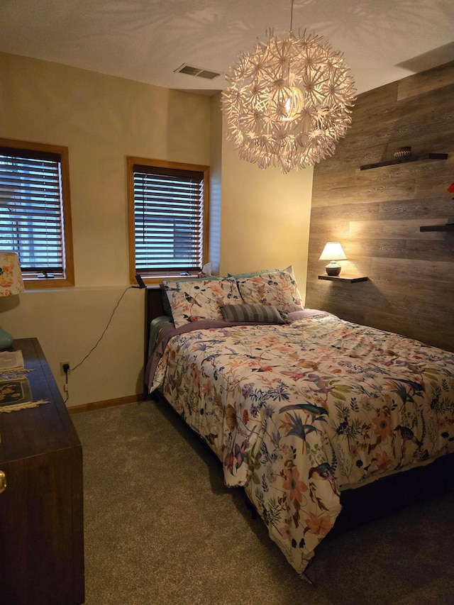 carpeted bedroom with visible vents, baseboards, and an inviting chandelier